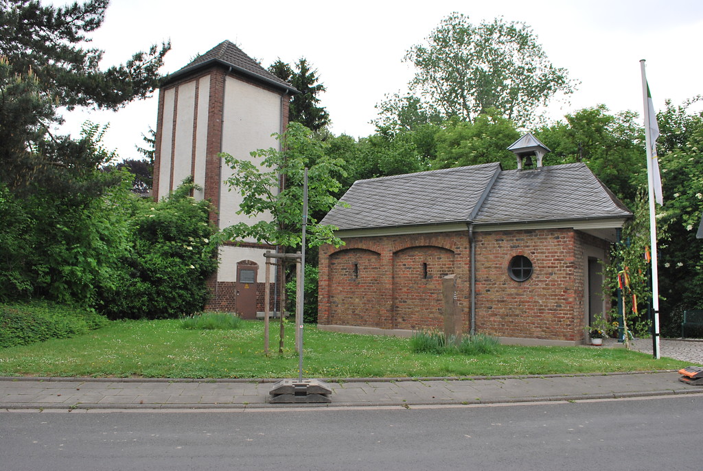 Die Turmtrafostation und die Kapelle stehen neben dem Doktorshof im Ortskern von Auweiler (2014).
