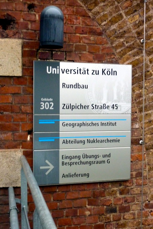 Informationsschild der Universität zu Köln neben der Haupteingangstür des Rundbaus (2014)