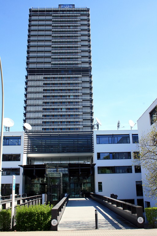 Der Eingangsbereich zum Gebäudekomplex der Deutschen Welle von der Kurt-Schumacher-Straße in Bonn (2015); im Hintergrund das frühere Abgeordnetenhochhaus "Langer Eugen".