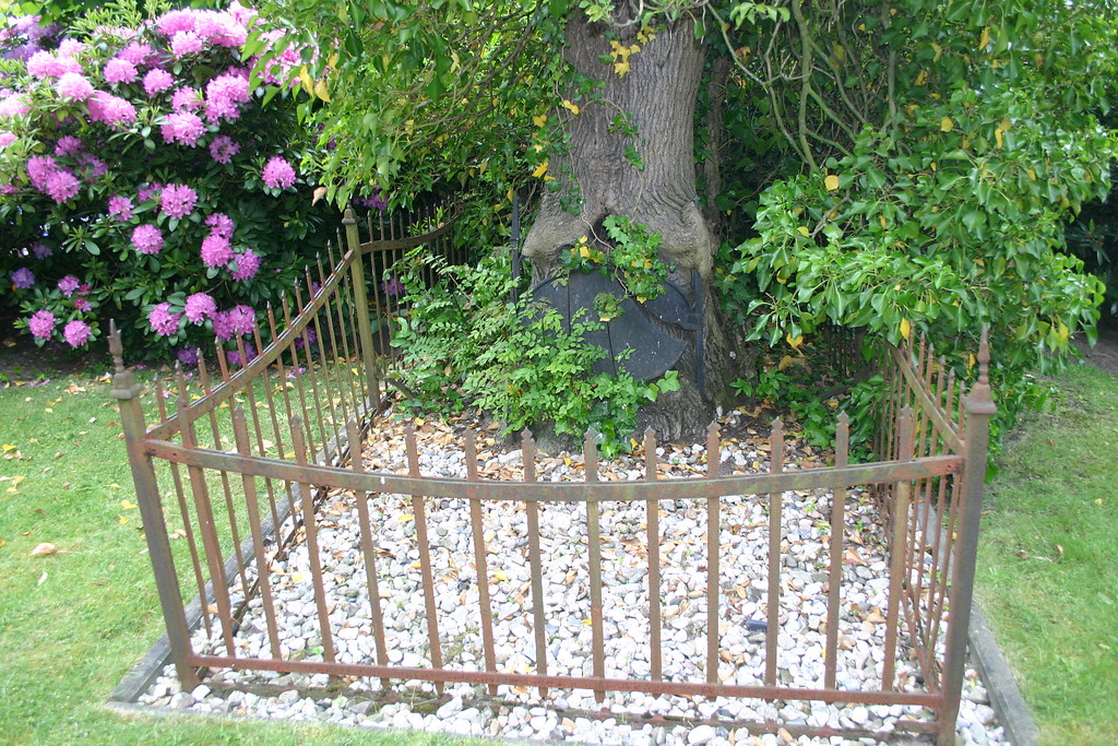 Grabplatte am Fuß eines Baumes. Teil des alten Friedhofs "De Widow" an der evangelischen Kirche in Schermbeck-Gahlen (2008).