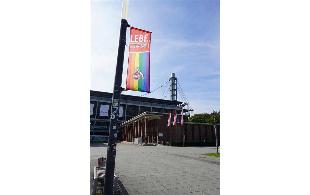 Eine sich zur Vielfalt der Stadt Köln bekennende Fahne auf dem Oskar-Rehfeldt-Weg vor dem RheinEnergie Stadion im Sportpark in Köln-Müngersdorf (2021)