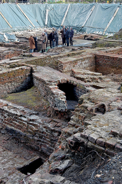 Blick über die Ausgrabungen mit Gebäudefundamenten und gemauerten Kanälen
