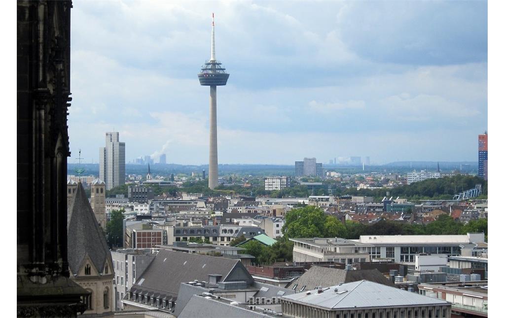 Blick vom Dach des Doms über die Stadt Köln in Richtung Westen, mittig ist der Fernseh- und Radio-Sendeturm "Colonius" zu sehen und im Hintergrund die rund 30 Kilometer entfernten Braunkohlekraftwerke bei Grevenbroich (2014)