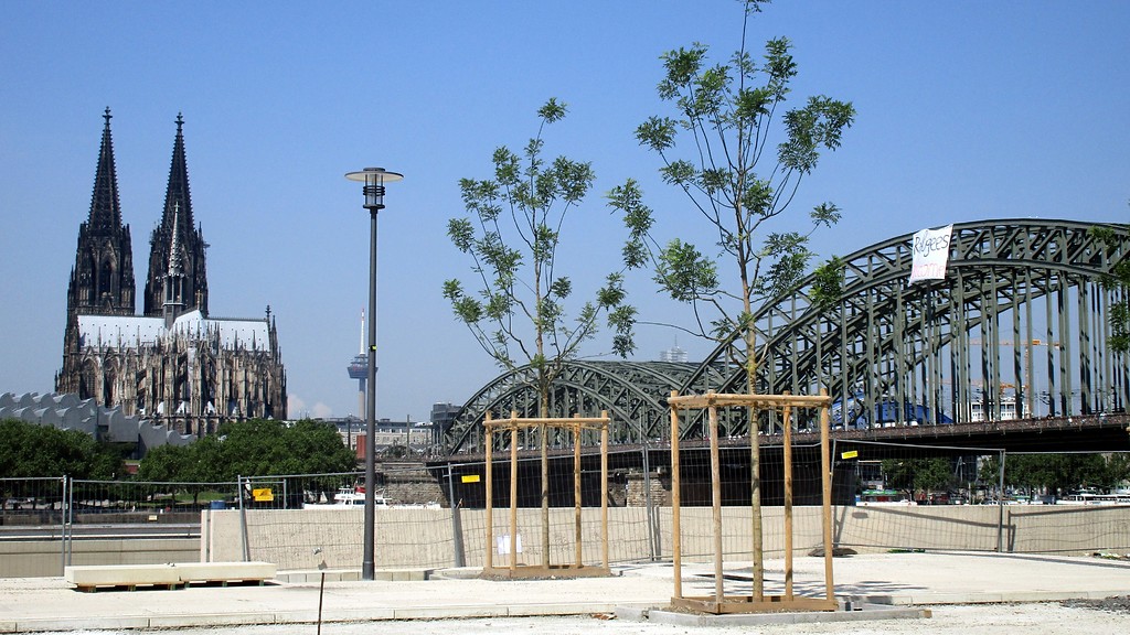 Blick vom Köln-Deutzer Rheinboulevard auf den Kölner Dom und die Hohenzollernbrücke (2016). Am mittleren Bogen der Brücke haben Aktivisten ein Transparent mit der Aufschrift "Refugees welcome" ("Flüchtlinge willkommen") aufgehangen.