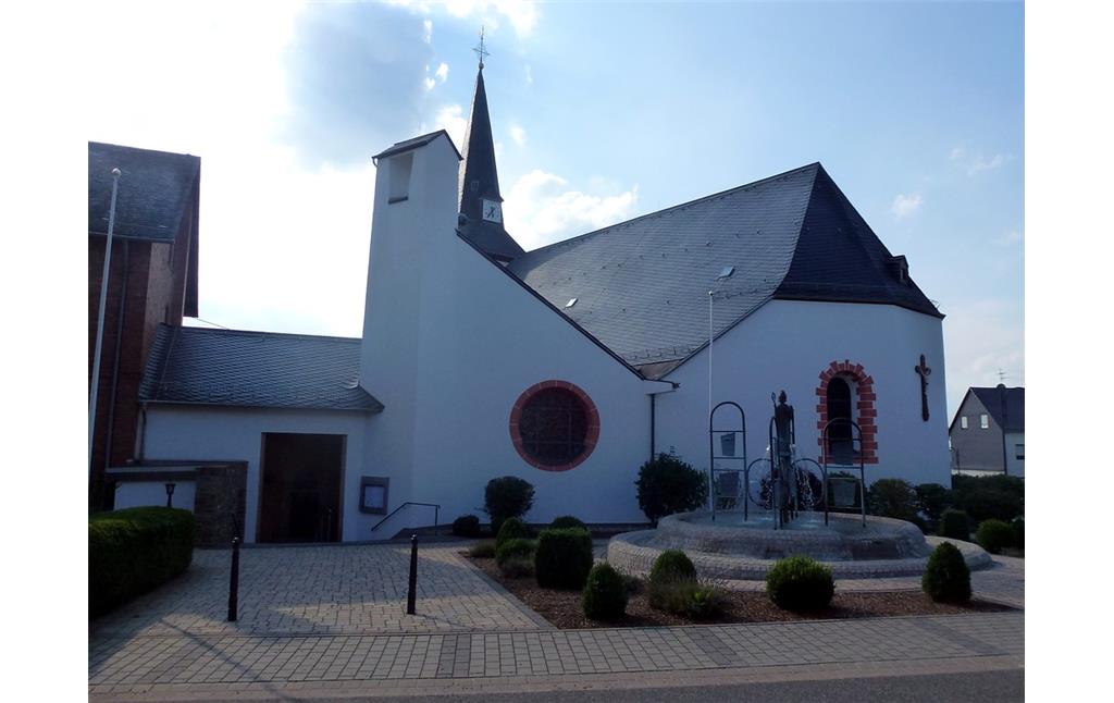 Katholische Pfarrkirche Sankt Lambertus in Halsenbach mit dem Lambertusbrunnen auf dem Kirchenvorplatz (2014)