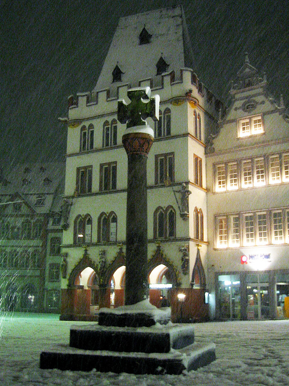Das mittelalterlichen Marktkreuz (heute eine Kopie) auf dem Trierer Hauptmarkt, dahinter das gotische Gebäude 'Steipe' (2004)