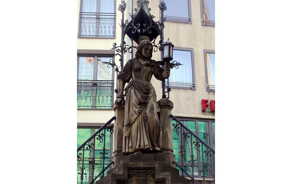 Heinzelmännchenbrunnen Köln: Figur der Schneidersfrau oben auf dem zentralen Sockel über den Wasserbecken (2020).