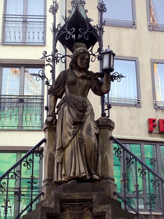 Heinzelmännchenbrunnen Köln: Figur der Schneidersfrau oben auf dem zentralen Sockel über den Wasserbecken (2020).