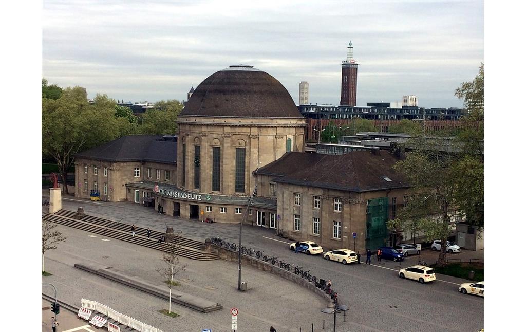 Empfangsgebäude des Bahnhofs Köln Messe/Deutz (2018) mit einem Teil des Bahnhofsvorplatzes, im Hintergrund der Messeturm.
