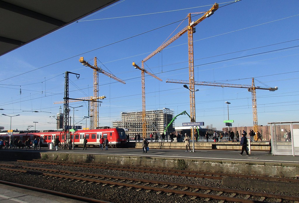 Baukräne über einer Großbaustelle der KoelnMesse in Deutz, Blick von einem Bahnsteig des Bahnhofs Köln Messe/Deutz in Richtung des Barmer Platzes (2018).