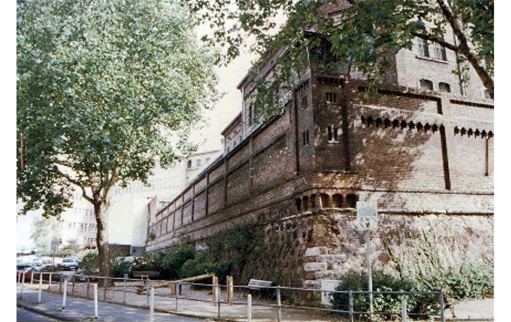 Blick auf die Bastionsmauer der Justizvollzugsanstalt Bonn an der Ecke Annagraben / Alexanderstraße (vor 1995). Unter dem als Eckrisalit ausgeführten Wachttürmchen ist eine barocke Kartusche mit kurfürstlichem Wappen in die Mauer eingelassen.