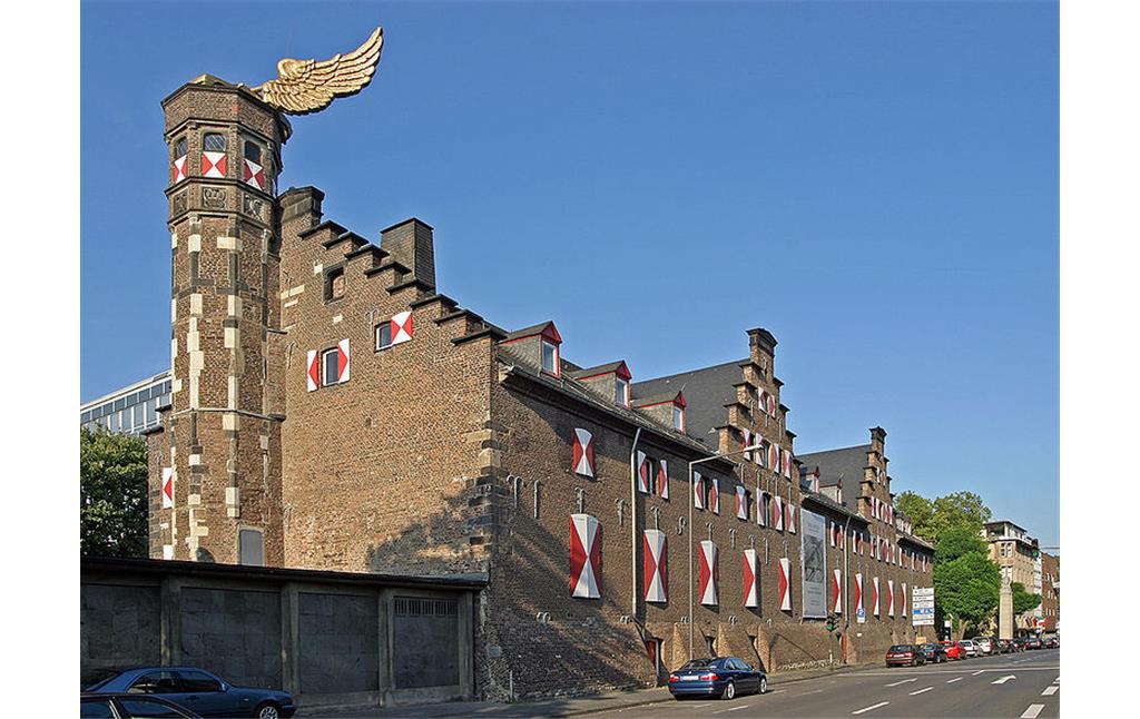 Das Zeughaus in Köln mit historischem Treppenturm und dem darauf befestigten Kunstwerk "Goldener Vogel" von HA Schult (2004).