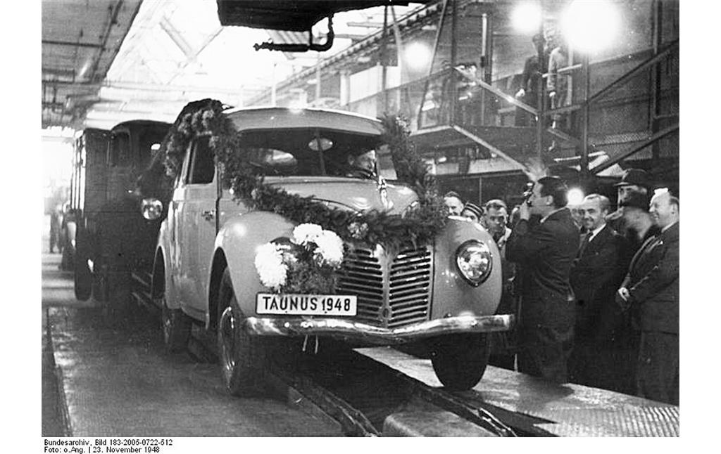 Der erste Kölner Nachkriegs-Ford, ein festlich geschmückter Taunus G73A ("Buckeltaunus"), läuft am 23. November 1948 vom Fließband der Fordwerke in Niehl.