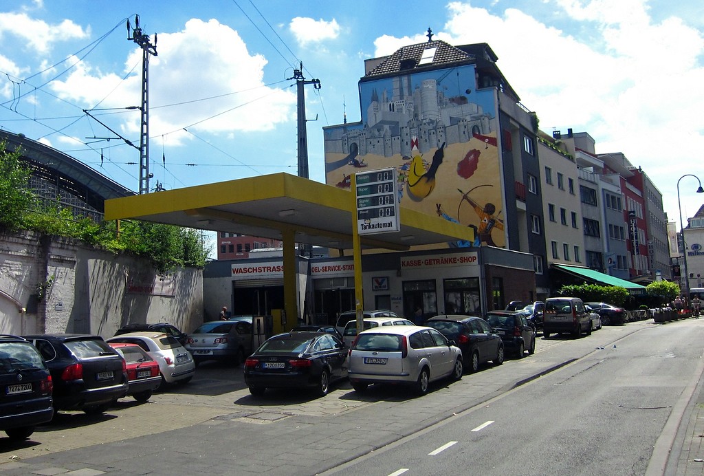 Am Standort der früheren Tankstelle in der Kölner Marzellenstraße werden heute ein KFZ-Service und eine Waschanlage betrieben (2015). Die Fassade des Hauses dahinter ist durch ein großformatiges Graffiti gestaltet.