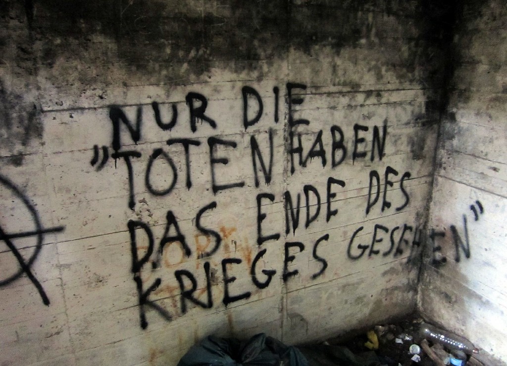 Stahlbeton-Bunker an der Artilleriestellung Sicherheitsstand 11 in der Wahner Heide (2011). Das Graffito im Inneren lautet "Nur die Toten haben das Ende des Krieges gesehen".