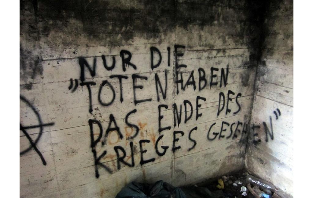 Stahlbeton-Bunker an der Artilleriestellung Sicherheitsstand 11 in der Wahner Heide (2011). Das Graffito im Inneren lautet "Nur die Toten haben das Ende des Krieges gesehen".