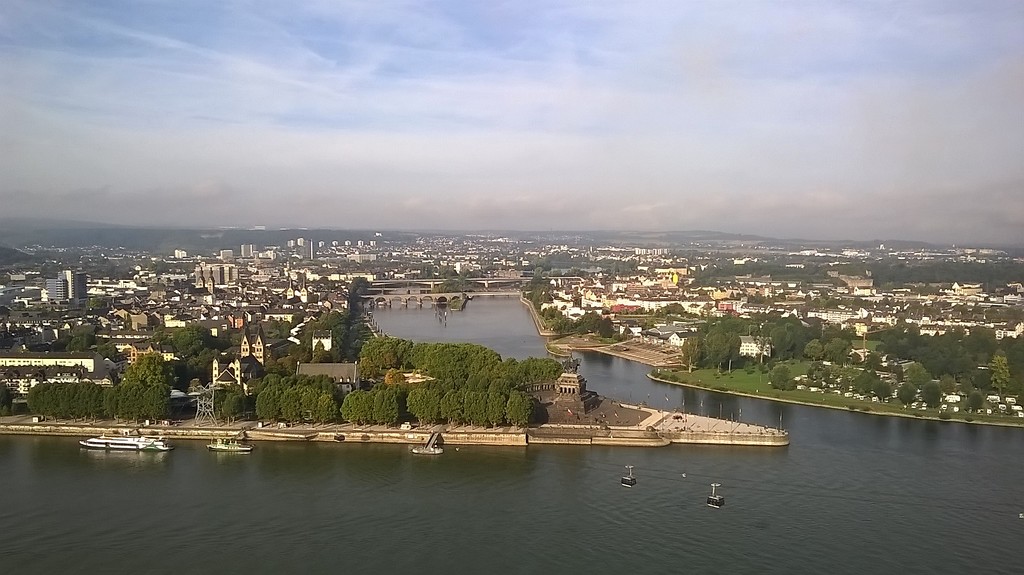 Das Deutsche Eck in Koblenz, am Zusammenfluss von Rhein und Mosel, mit dem Kaiser-Wilhelm-Denkmal von der Festung Ehrenbreitstein aus (2014). In der Bildmitte ist die "Balduinbrücke" über die Mosel zu sehen.