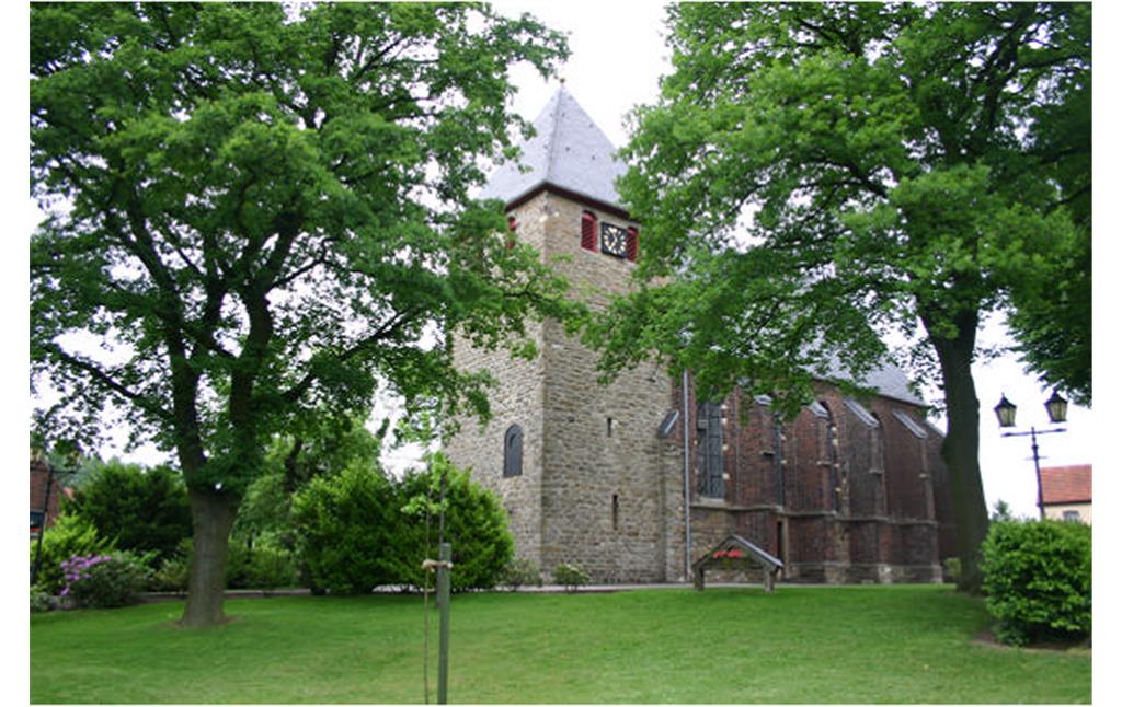 Die Gahlener Dorfkirche, fotografiert von einer Wiese aus, die zum Mühlenteich führt. Teile der Kirche sind von Bäumen abgedeckt.