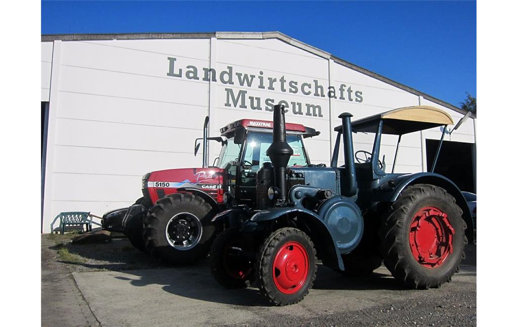 Ein historischer "Lanz"-Bulldog vor einem modernen Traktor "Case" am Eingang zum Landwirtschaftsmuseum in der Gehöftgruppe Sinsteden bei Rommerskirchen (2014).