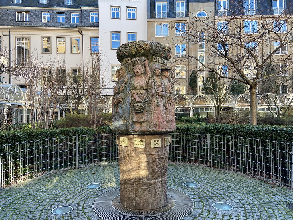 Der Kölner Frauenbrunnen im Innenhof der Wohnanlage "An Farina" inmitten einer kleinen Platzanlage (2023).