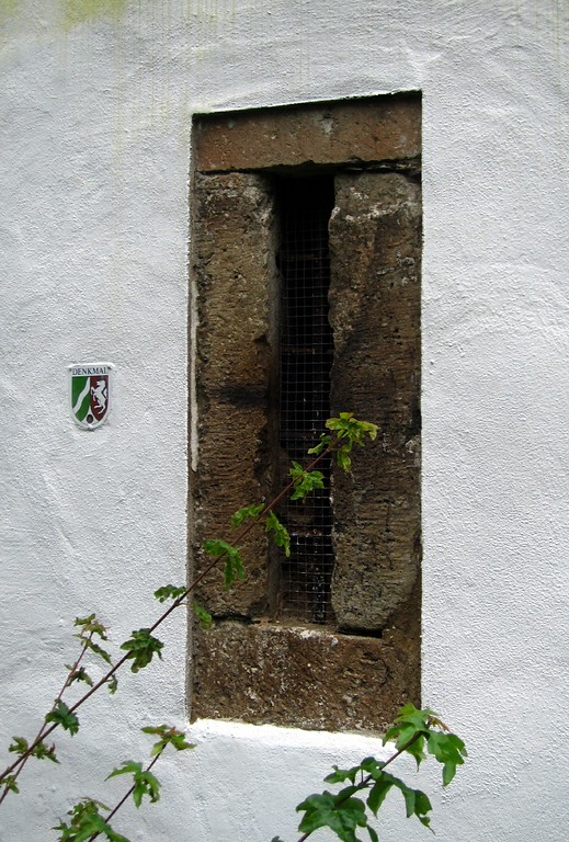 Denkmalplakette neben einem schmalen Fenster am Hexenturm in Bornheim-Walberberg (2013)