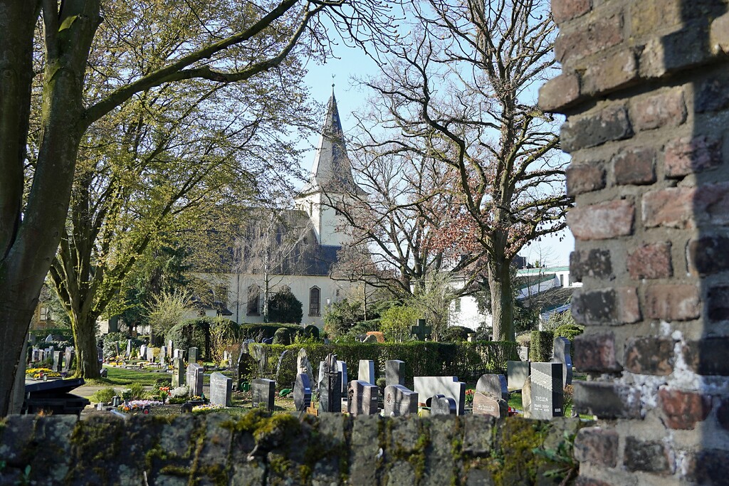 Blick über den Friedhof auf die alte Dorfkirche St. Cosmas und Damian in Weiler, heute Stadtteil Köln-Volkhoven/Weiler (2023).