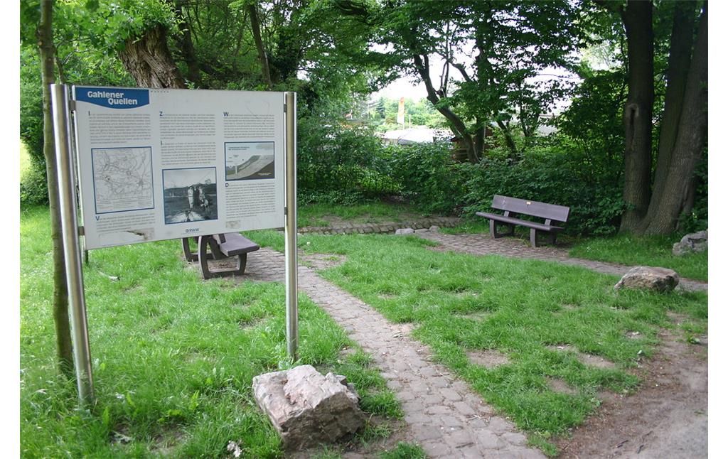 Informationstafel vor einem kleinen Platz mit Sitzbänken (2008). Die Überschrift der Tafel lautet "Gahlener Quellen".