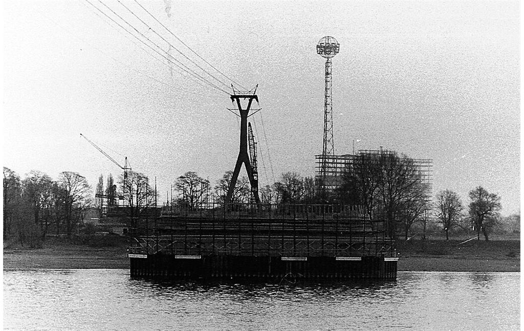 Historische Aufnahme vom Köln-Deutzer Rheinufer (um 1962/63): Im Bild die Seilbahn von Riehl nach Deutz, dahinter der Fordturm im Rheinpark und die Baustelle des Klöckner-Humboldt-Deutz-Hochhauses, im Vordergrund ein im Bau befindlicher Strompfeiler für die Zoobrücke.
