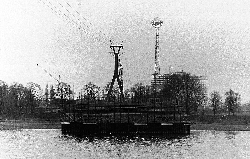 Historische Aufnahme vom Köln-Deutzer Rheinufer (um 1962/63): Im Bild die Seilbahn von Riehl nach Deutz, dahinter der Fordturm im Rheinpark und die Baustelle des Klöckner-Humboldt-Deutz-Hochhauses, im Vordergrund ein im Bau befindlicher Strompfeiler für die Zoobrücke.