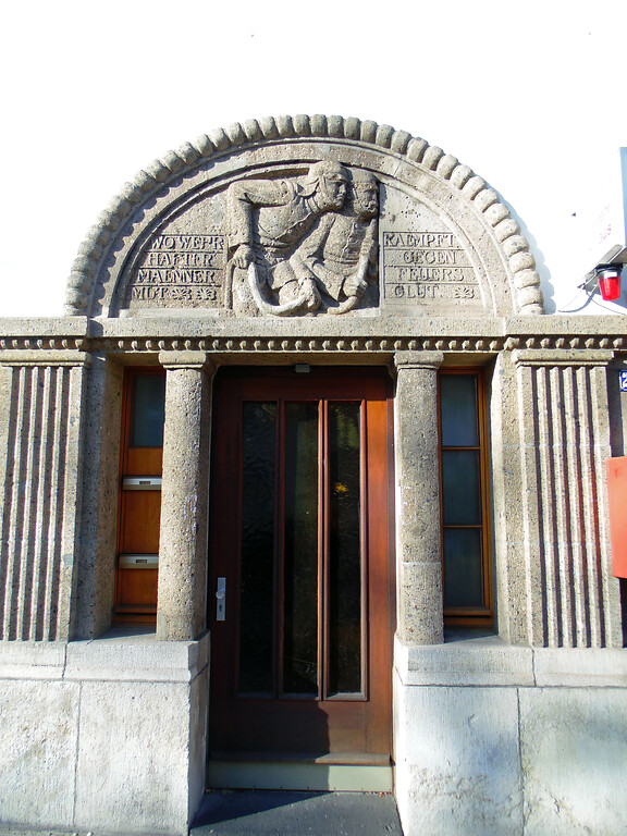 Die Eingangstür der Feuerwache Lindenthal in Köln-Lindenthal mit einem Relief darüber (2020)