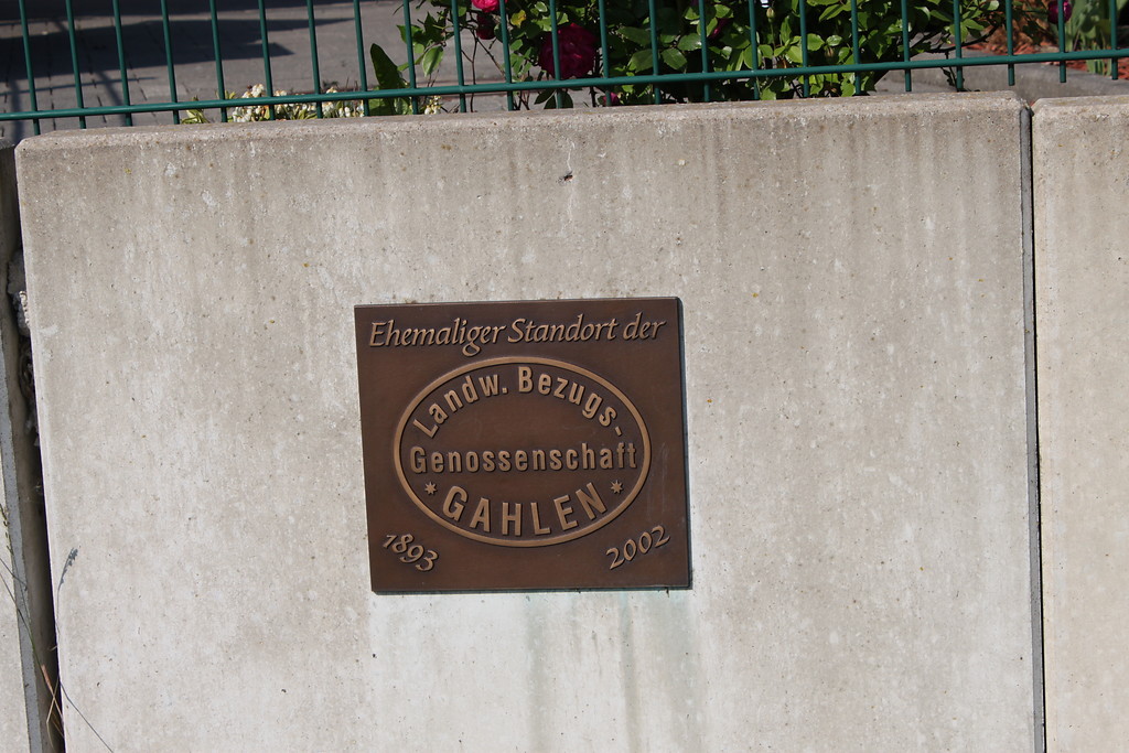 Bronzetafel zur Erinnerung an den ehemaligen Standort der Landwirtschaftlichen Bezugs-Genossenschaft an der Ecke Kirchstr./Steinbergweg in Schermbeck-Gahlen. Heute steht hier eine Siedlung (2014).