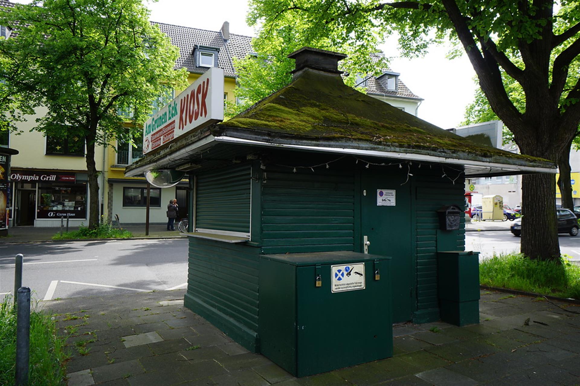 Der hölzerne, grün gestrichene und von spitzen Dach mit mittigem Schornstein gekrönte kleine Kiosk heißt "Am Grünen Eck". Er steht vor der Siedlung "Grüner Hof", was wohl auch seinen Namen erklärt. &copy; Martina Gelhar / Landschaftsverband Rheinland