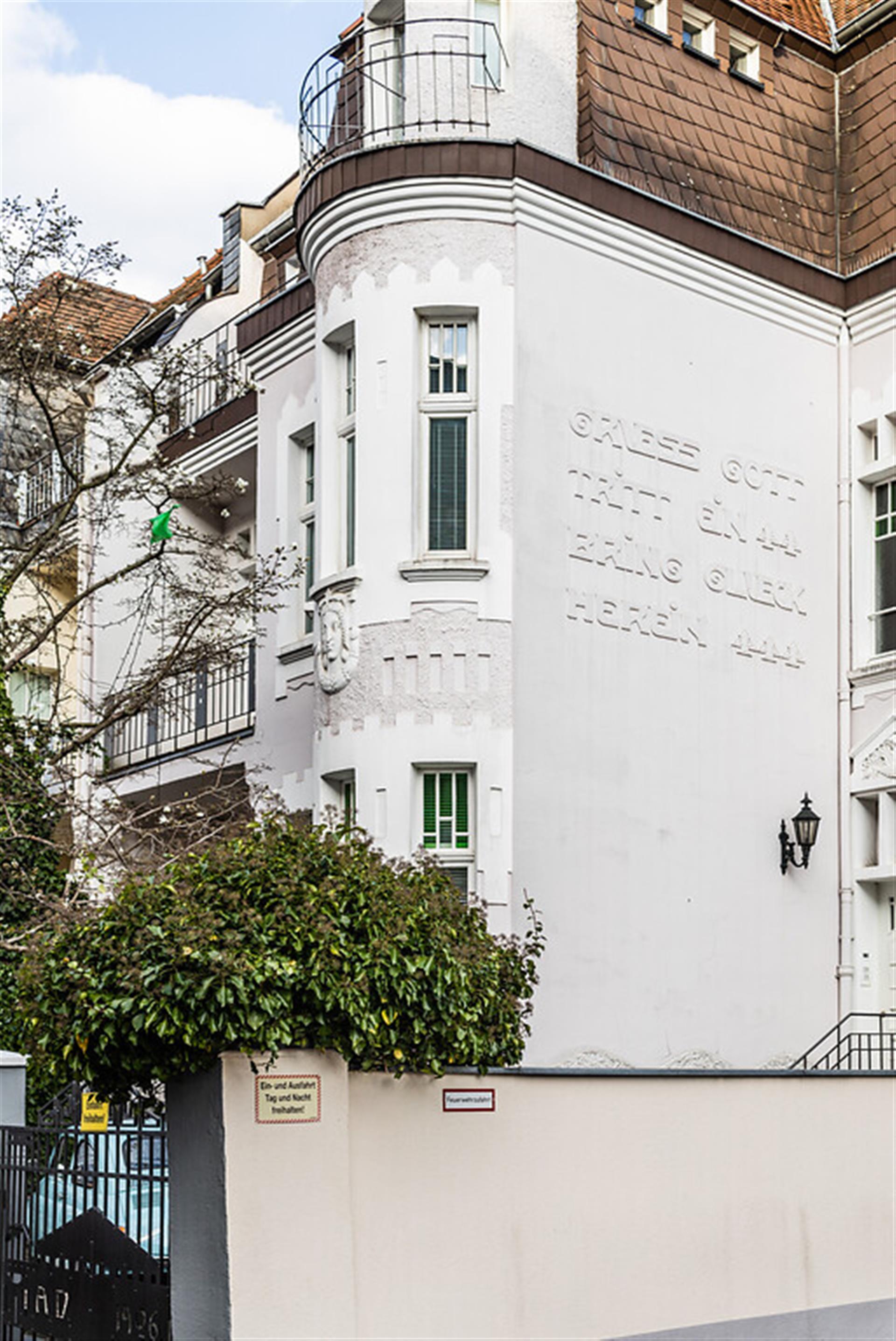 Wohnhaus in der Stammheimer Straße in Köln-Riehl (2022). Auf der Fassade steht geschrieben: "Gruess Gott tritt ein - Bring Glueck herein". &copy; Sebastian Löder / CC-BY 4.0