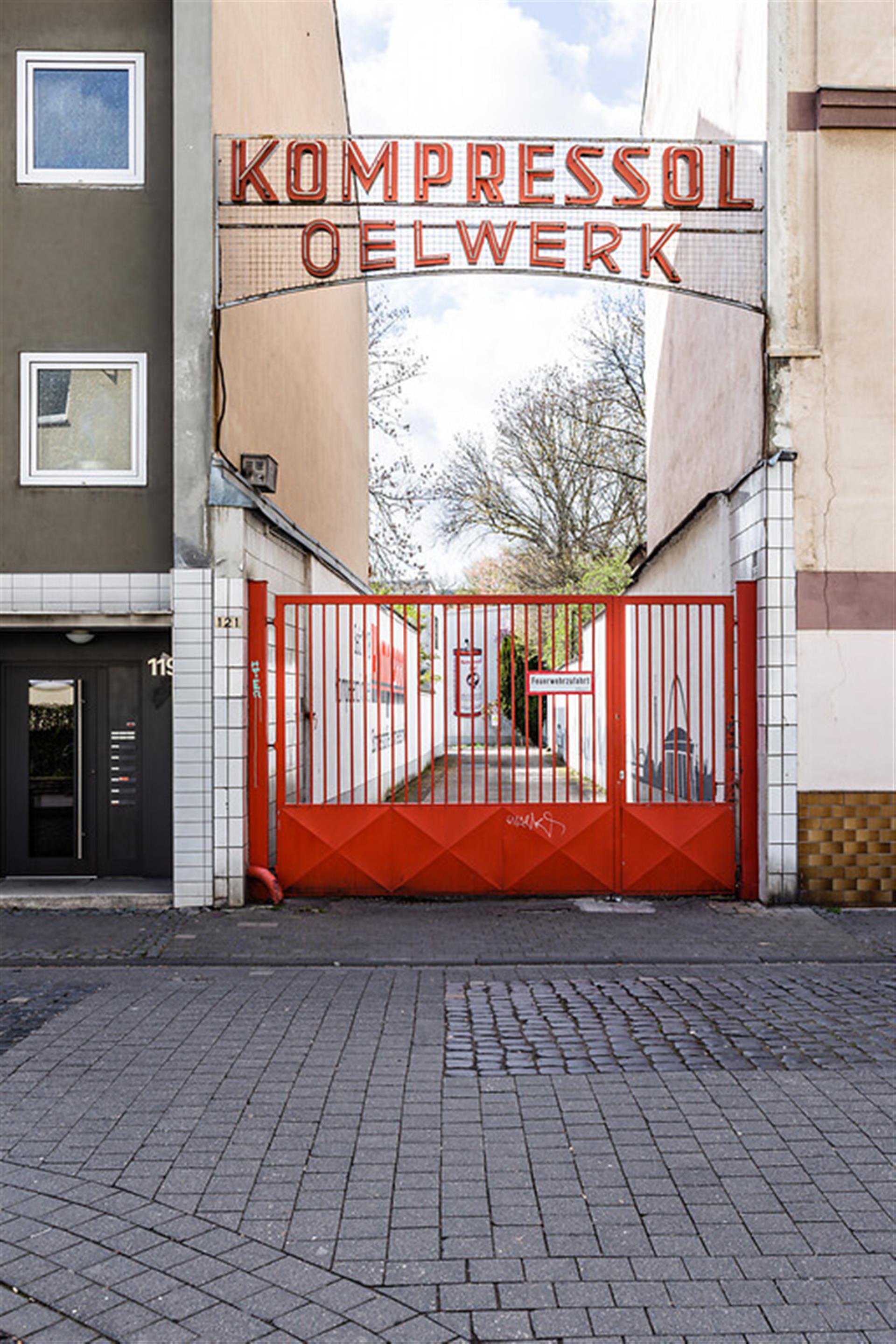 Eingangstor zur Kompressol-Oel Verkaufs GmbH in Köln-Nippes (2019). Die Firma stellt seit über hundert Jahren verschiedene Schmierstoffe her. &copy; Sebastian Löder / CC BY 4.0