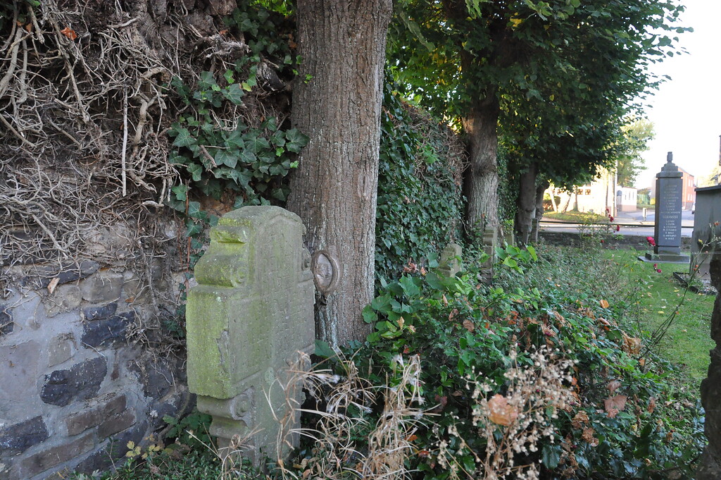 Historische Grabsteine und Spalierlinden an der Friedhofsmauer in Hemmerich (2014)