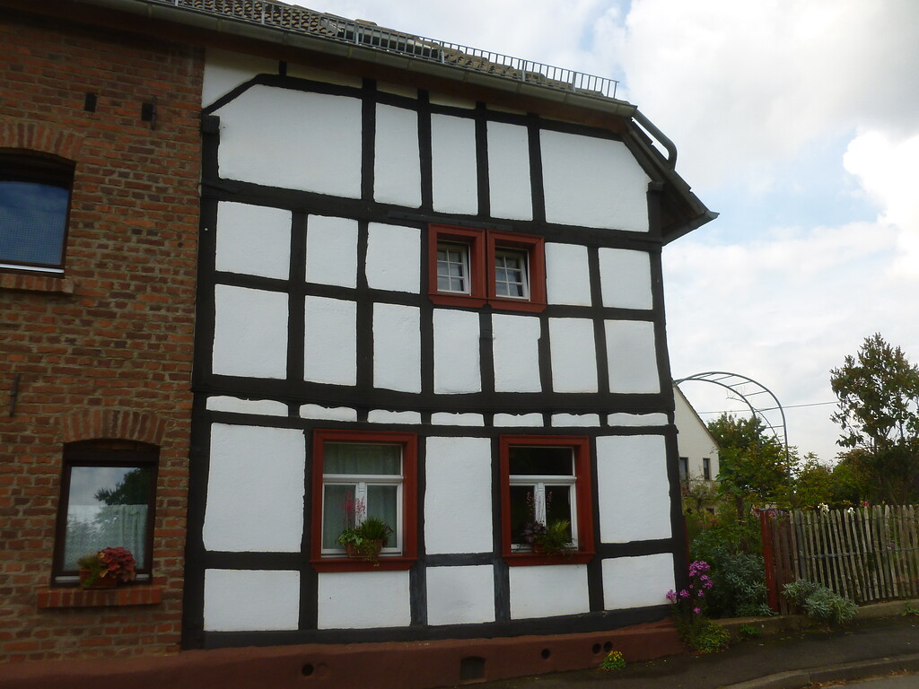 Fachwerkhaus mit rechtwinkligen Balken und roten Fenstereinfassungen in Lückerath (2014)