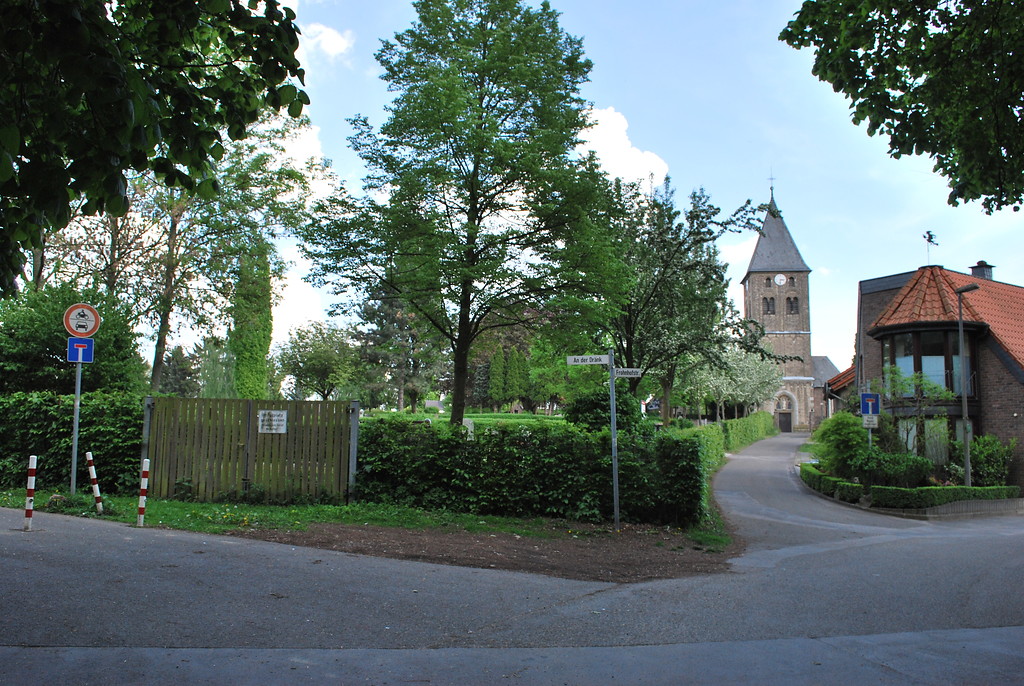 Kreuzung "An der Dränk" und "Fronhofstraße" in Köln-Esch mit Blick auf den historischen Friedhof und die romanische St. Martinus Kirche (2014).