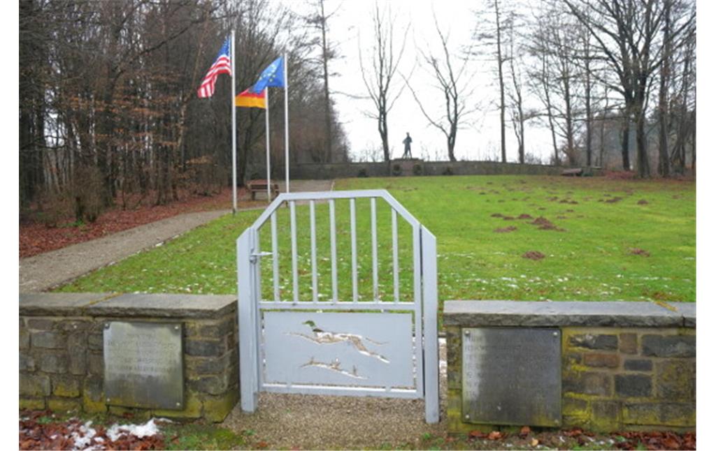 Bild 1: Die sogenannte "Windhund-Anlage" neben der Kriegsgräberstätte Vossenack. Im Vordergrund ist das 1991 neu angebrachte Tor mit dem Emblem der "Windhunde" zu erkennen (Aufnahme vom 27.01.2015).