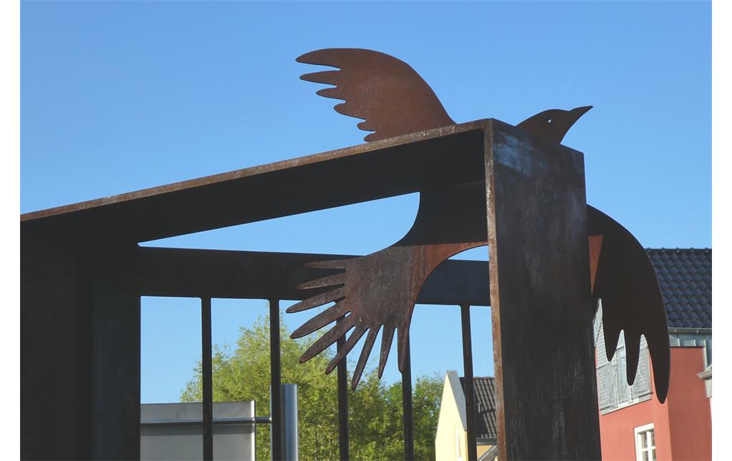 Detail des Mahnmals von Nideggen: Eine Taube, die aus einer halb geöffneten Tür in die Freiheit fliegt.