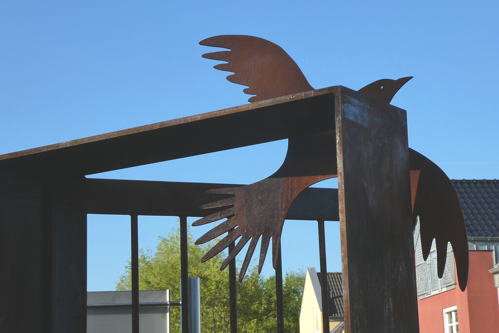 Detail des Mahnmals von Nideggen: Eine Taube, die aus einer halb geöffneten Tür in die Freiheit fliegt.