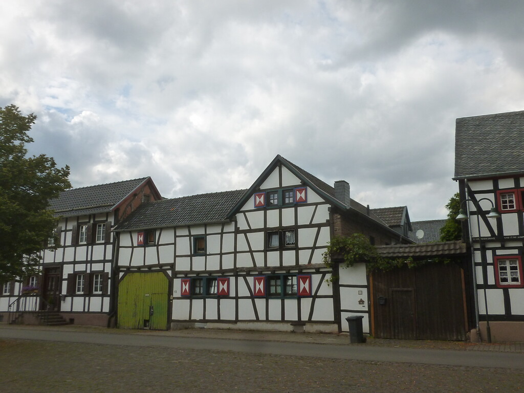 Diese Fachwerkgebäude in Hostel weisen farbig bemalte Fensterholzrahmen, teilweise Schlagläden und Hoftore auf. (2014)