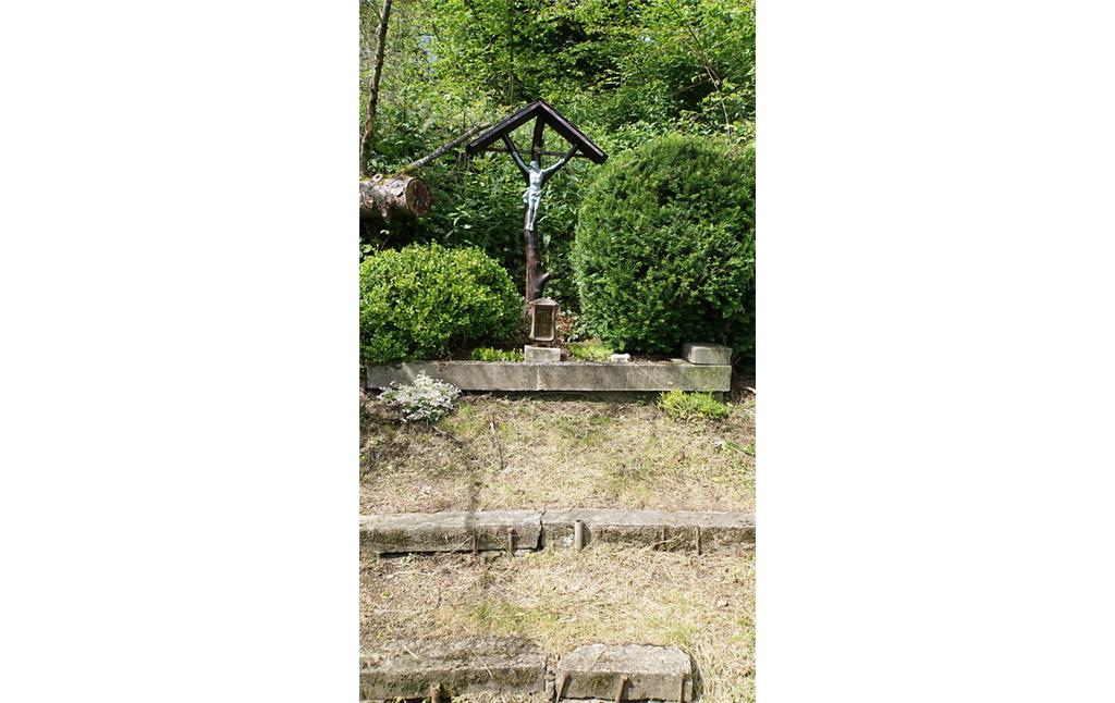 Das Gedenkkreuz steht etwas oberhalb des Weges im Hang und ist durch eine Bohlentreppe erschlossen (2021).
