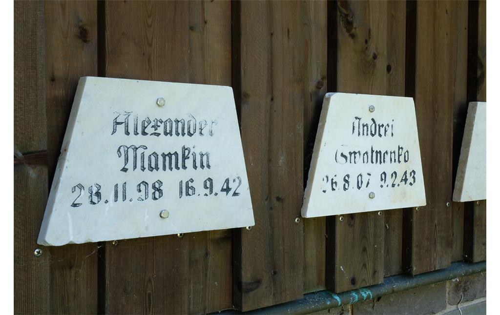 Bild 20: Die ersten beiden von 14 an der Rückseite des Mehrzweckgebäudes angebrachten Marmortafeln auf der Gräberstätte Rurberg, die zuvor auf dem Waldfriedhof Eschweiler angebracht waren (2021).