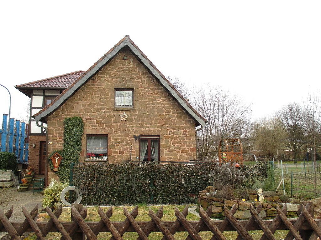 Aus massiven Bruchsteinen erbautes Haus in Boich mit angebautem Fachwerkgebäude, angrenzend eine Weide (2015).