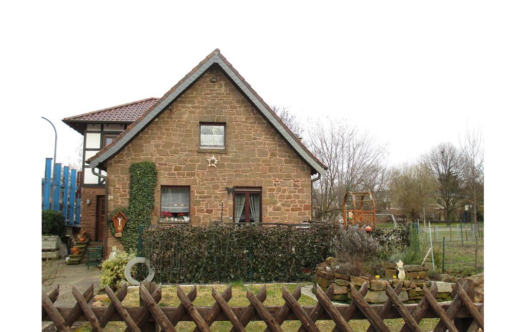 Aus massiven Bruchsteinen erbautes Haus in Boich mit angebautem Fachwerkgebäude, angrenzend eine Weide (2015).
