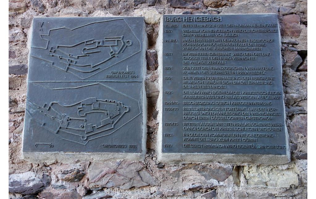 In eine Burgmauer in Tornähe ist eine Informationstafel eingelassen, auf der die wichtigsten Eckdaten der Burg über die Jahrhunderte hinweg sowie ihr Grundriss verzeichnet sind (2020).
