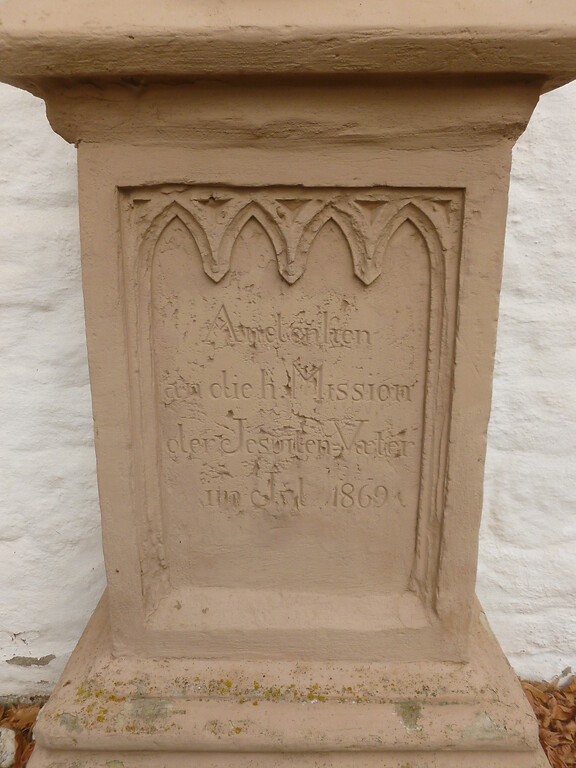 Der Schriftzug auf dem Sockel des Sandsteinkreuzes an der Pfarrkirche St. Andreas in Glehn trägt die Inschrift: "Andenken an die H. Mission der Jesuiten-Väter im Jul. 1869" (2014)