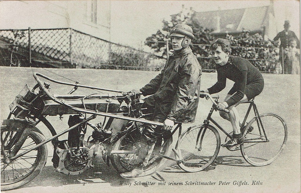 Historische Postkarte (undatiert, wohl vor 1905): Der Kölner Radsportler Willy Schmitter hinter seinem Schrittmacher Peter Giffels bei einem Radrennen auf der Riehler Radrennbahn.