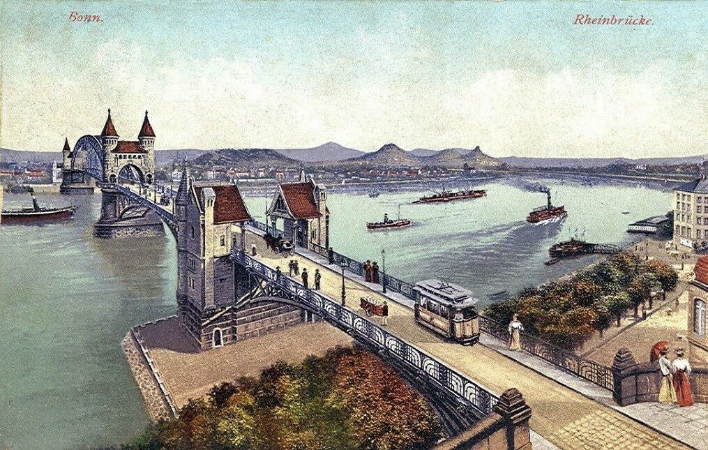 Die undatierte Farbpostkarte "Bonn. Rheinbrücke" zeigt die Alte Rheinbrücke und das Bonner Flussufer, im Hintergrund ist das Siebengebirge zu sehen.