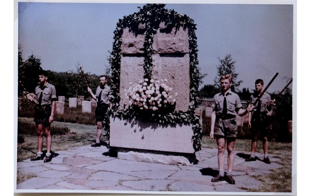 Bild 5: Am 2. Juli 1961 wurde die Gräberstätte Rurberg eingeweiht. Um das mit Pflanzen kaschierte Hochkreuz herum halten christliche Pfadfinder vom Stamm 'Karl der Große' aus Aachen Fackeln während der Zeremonie (1961).